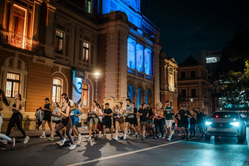 Corredores passando em frente a prédio histórico iluminado em Belo Horizonte